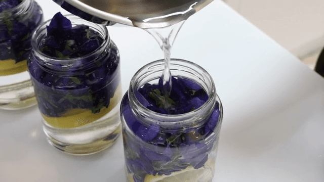 꽃이 담긴 병에 액체를 붓는 장면