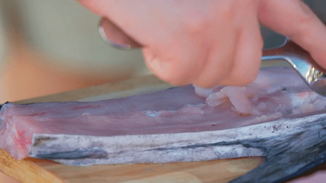 숟가락으로 생선을 손질하는 사람