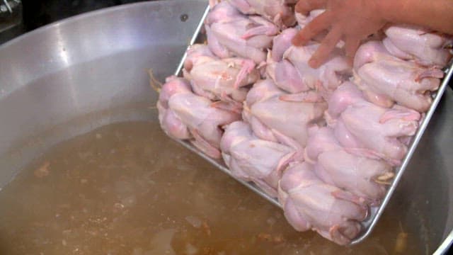 Chickens being boiled in a large pot