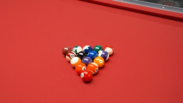 Billiard balls arranged on a red pool table