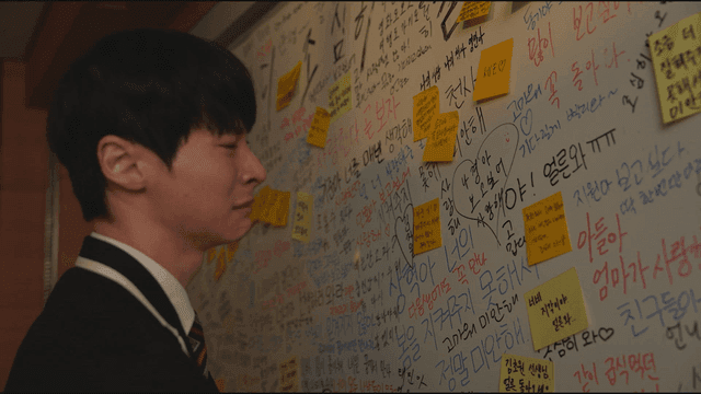 Boy cries after reading memorial written all over blackboard.