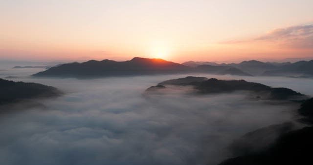 Sky Colored by Sunrise over Foggy Mountains