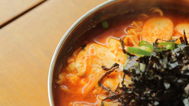 Spicy Korean rice cake ramen with seaweed garnish