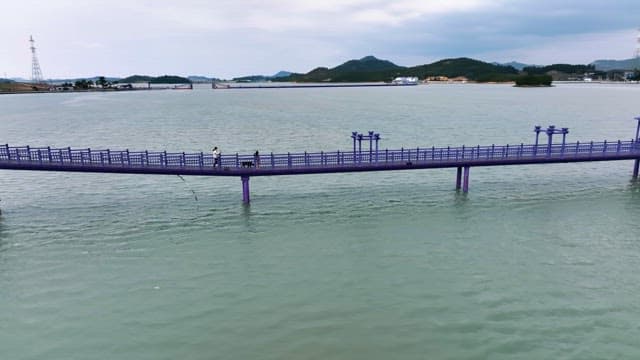 잔잔한 바다 위의 보라색 다리