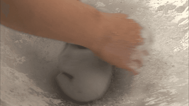 큰 그릇에서 반죽을 치대는 손