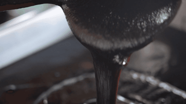 Thick sauce being poured from a ladle