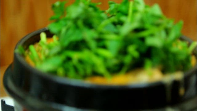 Boiling duck soup topped with water parsley