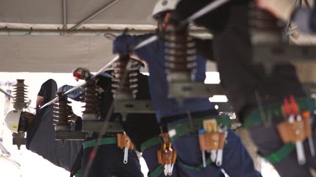 덮개가 있는 공간에서 전기 부품을 열심히 설치하는 기술자들