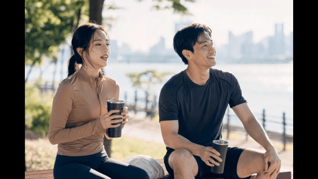 Couple relaxing by river after exercising