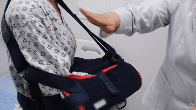 Doctor adjusting a patient's arm sling