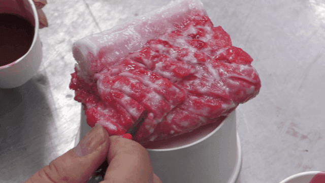 Craftsman painting model of raw meat with red dye