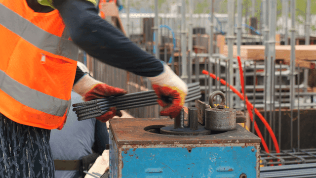 Construction worker bending steel bars