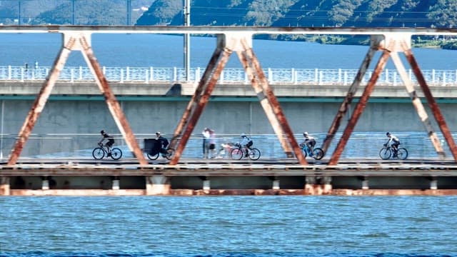 Cyclists riding on a bridge over a river