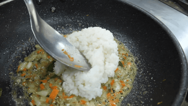 게 내장과 채소가 있는 팬에 부어지는 밥