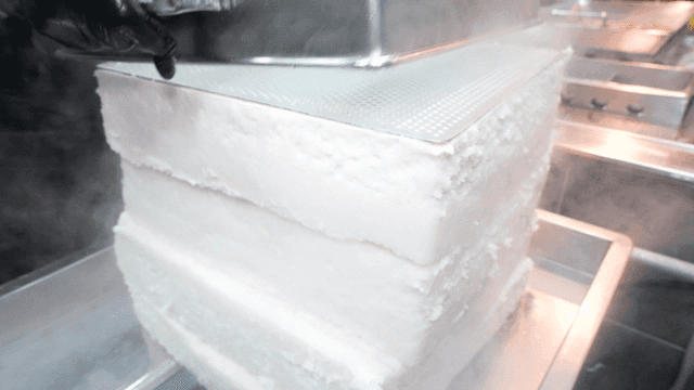 White rice cakes coming out of steamer in kitchen