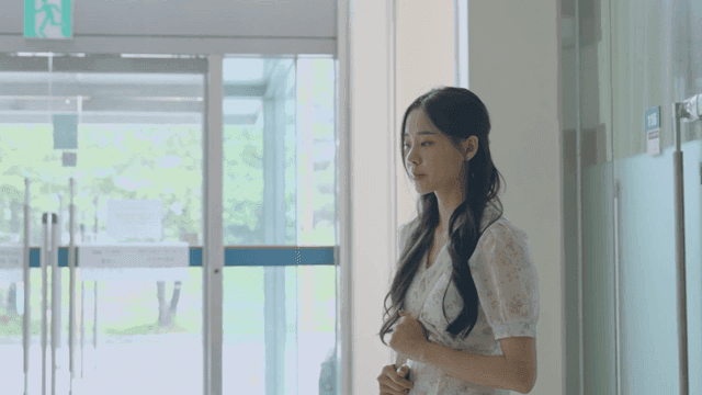 유리문 근처에 서 있는 여성