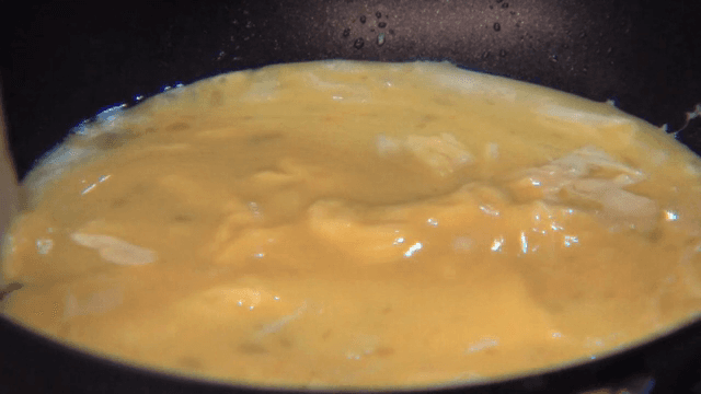 프라이팬에서 계란을 저으며 요리하는 장면