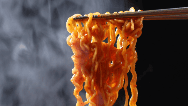 Steaming hot ramen noodles lifted by chopsticks