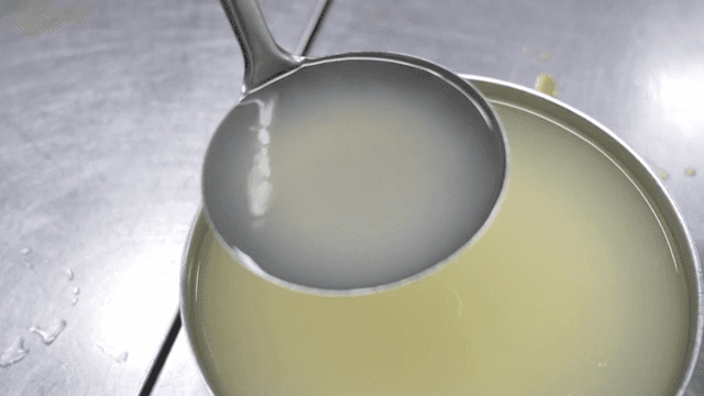 Ladle scooping liquid from a pot