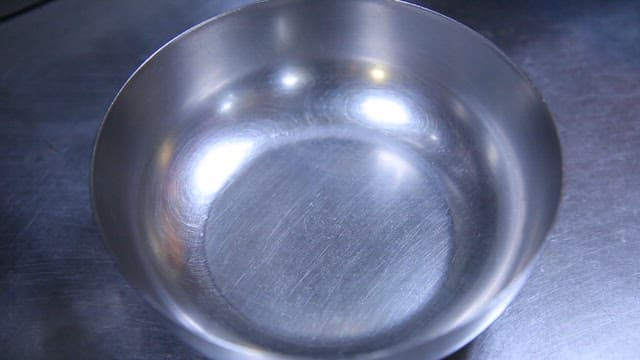 금속 그릇에 면을 담는 장면