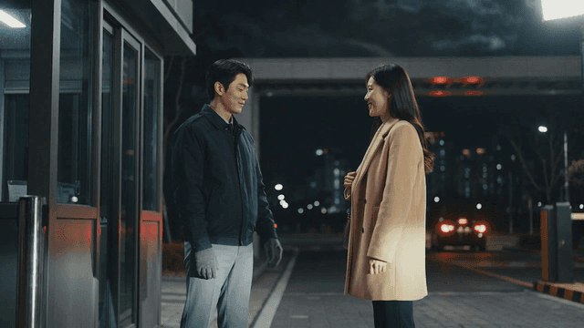 Security guard and resident talking at apartment main gate at night