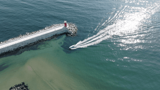 해안 등대 근처를 항해하는 보트