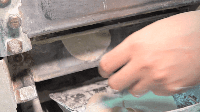 기계에서 만두피를 꺼내는 손