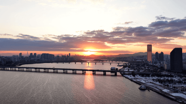 Sunset over a city with a river and bridges