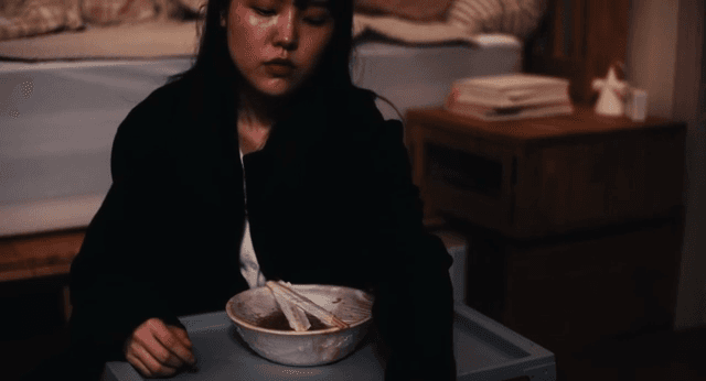 방바닥에 앉아 밥 먹을 준비를 하는 여성