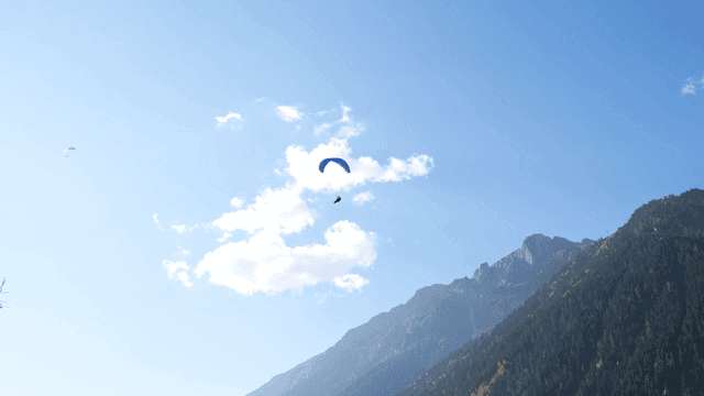 Paraglider soaring over a mountain landscape