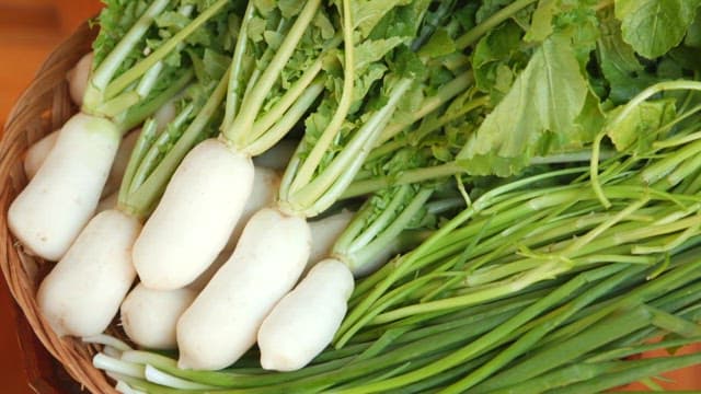 White fresh whole radish neatly plated in a wooden basket