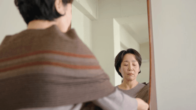 실내에서 거울을 보는 여성