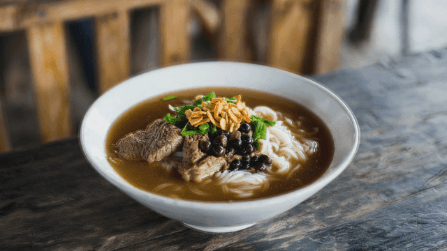 Beef Thai boat noodles on wooden table