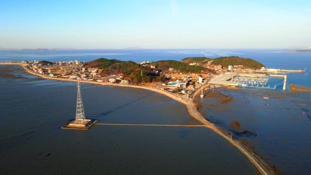 Island surrounded by the sea and hills with a view of the transmission towers