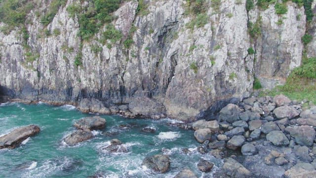 Rocky cliffs by the ocean with waves