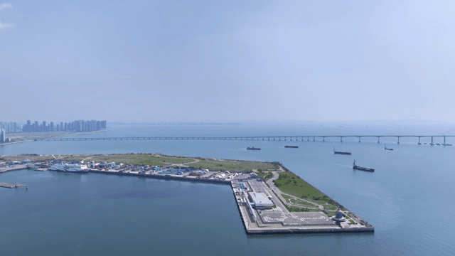 A coastal city with a bridge and ships