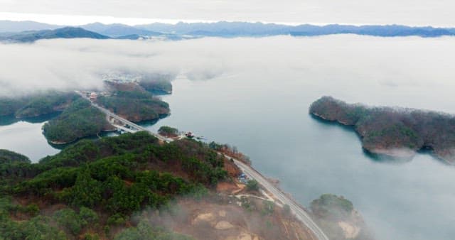 Misty Lake with Surrounding Mountains and Road