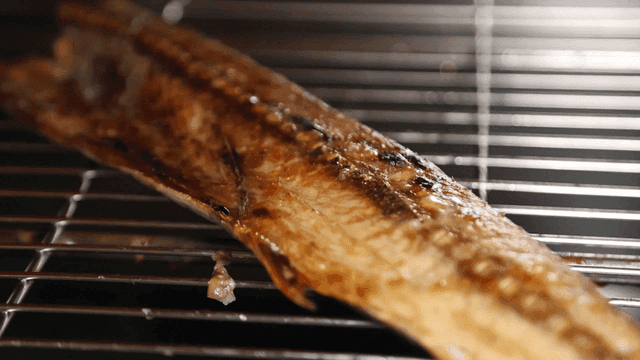 Grilled fish on metal shelf