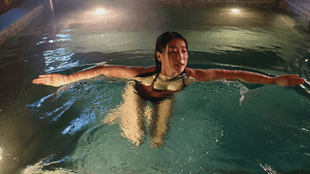 Women swimming in pool at night