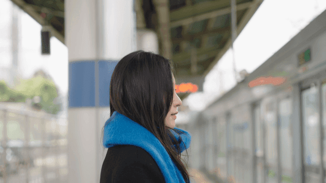 Profile of a woman waiting on a train station platform