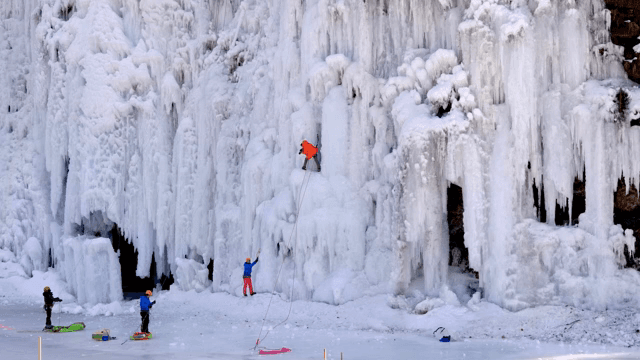 얼어붙은 폭포를 오르는 아이스 클라이머