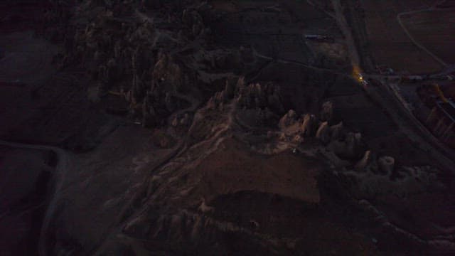 Hot Air Balloons Over Rocky Landscape at Dusk