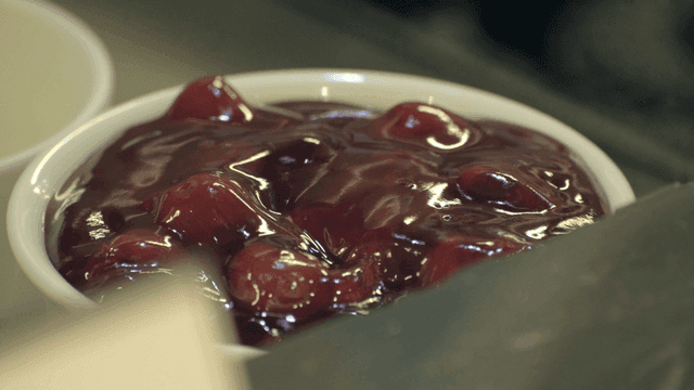 A bowl of cherry dessert with syrup