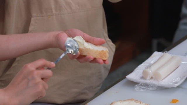 Chefs Spreading Cream Cheese on Bread