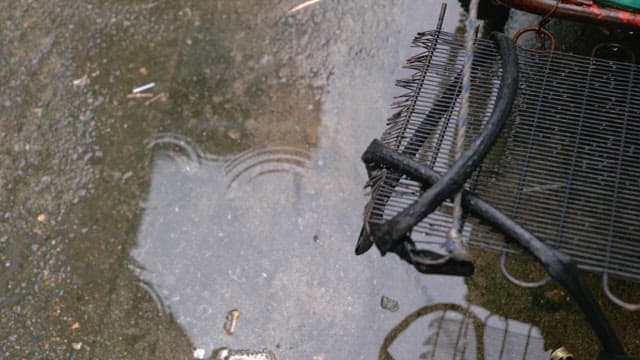 Puddles on wet ground on a cement floor on a rainy day