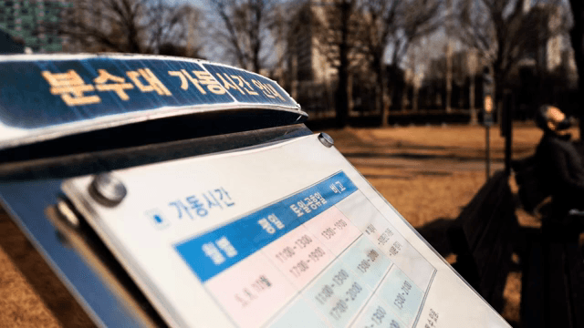 공원 표지판과 근처에서 휴식 중인 사람