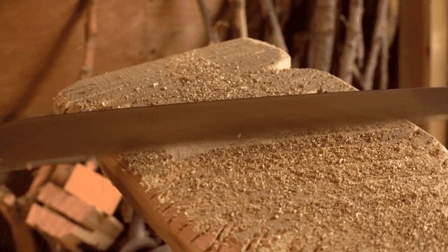 작업장에서 톱으로 나무를 자르는 모습