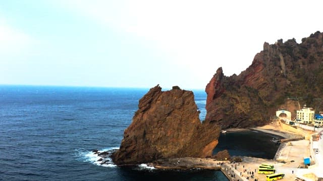 거대한 바위들이 있는 해안가 마을과 버스들