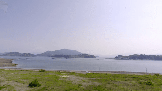 A calm sea with distant mountains