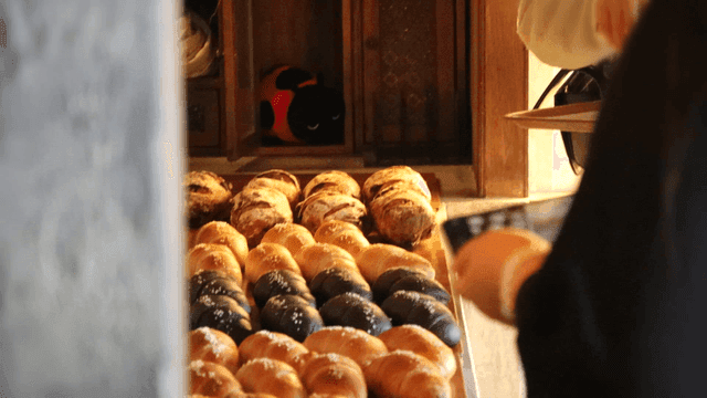 A person selecting bread in a bakery